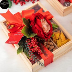 Luxury 9-compartment wooden Christmas snack box with red ribbon, premium nuts, dried fruit and chocolates by Graze & Bliss.