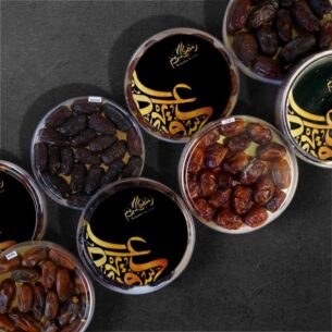 Ramadan date gift tubs with Safawi and Zamli dates in black and gold packaging.